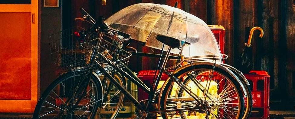 Un vélo qui prend la pluie avec un parapluie au dessus