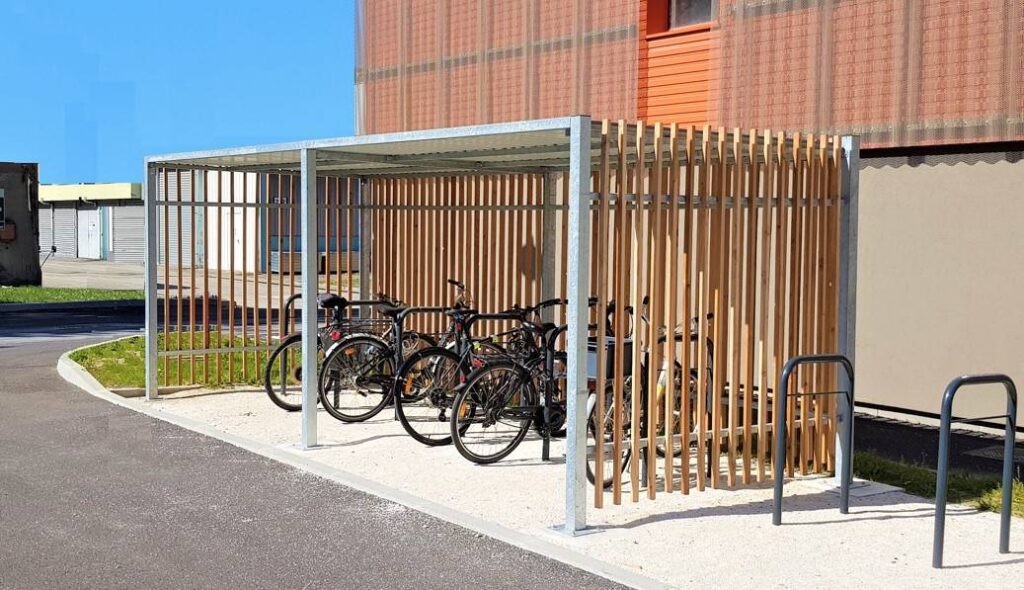 Abri vélo ouvert en bois après trois ans d'utilisation, avec vélos garés