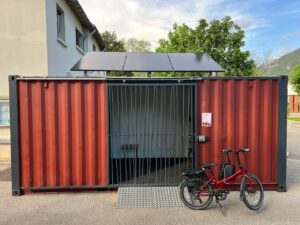 Abri vélo en container maritime recyclé avec panneaux solaires, offrant une solution de stationnement sécurisé et durable pour vélos électriques, installé par ByCommute.