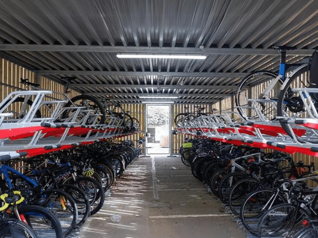 Arceaux doubles étages pour vélos installés dans un abri refuge ByCommute, offrant une capacité de stationnement optimisée et sécurisée pour de nombreux vélos. Idéal pour les entreprises et les zones urbaines à forte fréquentation.