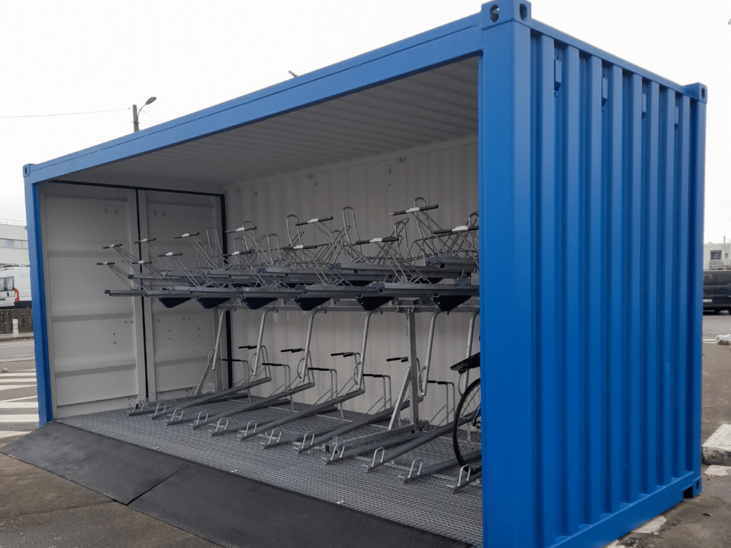 Photo d'un abri escale sur la base d'un container ouvert en bleu de 26 places de vélos sur doubles étages. Cet abri vélo, fait de container recyclé, est déplaçable et offre un stationnement sécurisé pour la mobilité douce. Format 4/3