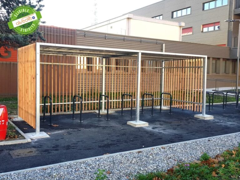 Abri vélo design en bois et métal avec arceaux de stationnement, situé devant un bâtiment.